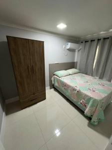 邦比尼亚斯Aparto Canto da Praia /40m d Mar的一间卧室配有一张床和一个木制橱柜