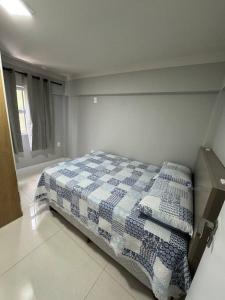 邦比尼亚斯Aparto Canto da Praia /40m d Mar的一间卧室配有一张带蓝色和白色被子的床