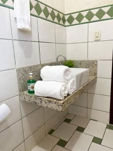 帕尔马斯Casa conforto e estilo的一间带水槽和架子毛巾的浴室