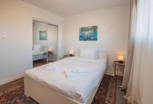 耶洛奈夫Yellowknife Downtown 50a ave Vacation Home的卧室配有白色的床和2条毛巾
