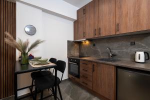 塞雷LP Citycenter Suite的厨房配有木制橱柜和带水槽的桌子。