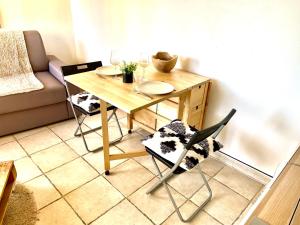 塞普特梅斯·莱瓦隆Studio entre Aix en Provence et Marseille et parking的客厅配有一张木桌和椅子