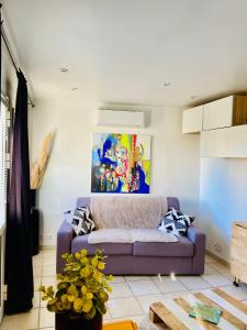 塞普特梅斯·莱瓦隆Studio entre Aix en Provence et Marseille et parking的客厅配有紫色沙发和绘画