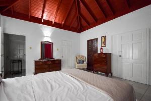 曼德维尔Harriott Heights的一间卧室设有一张大床、一个梳妆台和一扇门