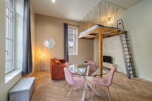 圣艾蒂安Le poudré Cours Fauriel magnifique appartement的一间设有玻璃桌和粉红色椅子的用餐室