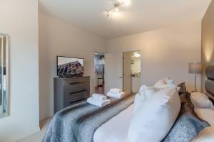 基西米Enjoy a Cozy 3 BR/Clubhouse/Near Disney and more的一间卧室配有带枕头的床铺和电视。