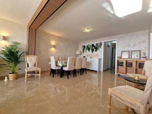 罗列特海岸Lloret Paradise Apartments的用餐室以及带桌椅的起居室。
