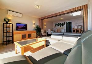 罗列特海岸Lloret Paradise Apartments的带沙发、桌子和电视的客厅