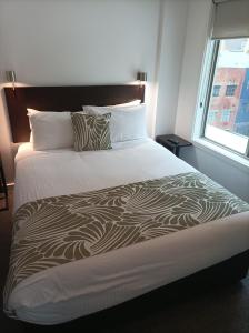 墨尔本布尔科高地酒店的一间卧室设有一张大床和窗户