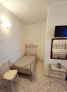 奥斯图尼Bed & Breakfast dei Colli的一间卧室配有一张床、一把椅子和镜子