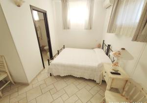 奥斯图尼Bed & Breakfast dei Colli的一间卧室配有一张床、一张桌子和一面镜子
