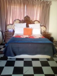 PhuthaditjhabaNafi Guesthouse的一间卧室配有一张带蓝色毯子的大床