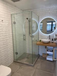 奥克兰66 Express luxury apartment in New Market Our apartments has Self-checkin System的一间带玻璃淋浴和水槽的浴室