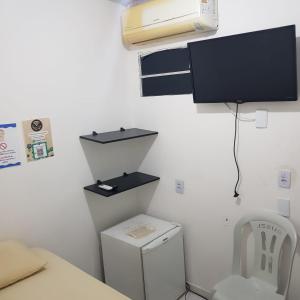若昂佩索阿Pousada Manaíra Buena Playa的客房设有卫生间和墙上的电视。