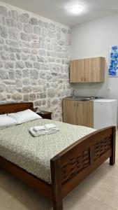 科托尔Filip Deluxe Rooms的一间卧室设有一张床和石墙