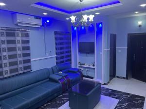 拉各斯Muniz Apartments的蓝色的客厅配有沙发和电视