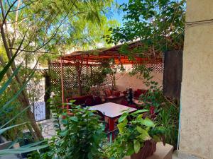 亚喀巴Al-Amer Hostel 1的花园内带桌椅的庭院