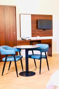 延布Safa PARK HOTEL YANBU فندق صفا بارك ينبع的一张桌子和两张蓝色椅子