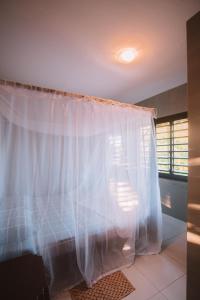 皮帕La Serena Hostel的卧室配有白色窗帘和窗户。
