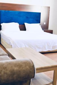 延布Safa PARK HOTEL YANBU فندق صفا بارك ينبع的一间卧室配有两张床、一张桌子和一把椅子
