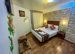 马丘比丘Machupicchu Adventure Hotel的一间卧室设有一张床和砖墙