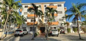 瓜亚卡内斯Residence Caribe的一座白色的大建筑,前面有棕榈树