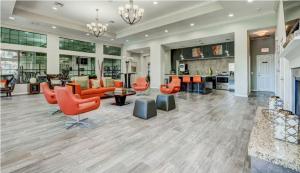 休斯顿Amazing Houston Apartment with Pool+ Fast Internet的大型客厅配有橙色椅子和沙发