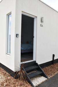 Capel SoundPeninsula Beachside Accommodation的一间白色的小房子,门打开