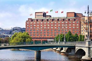 斯德哥尔摩斯德哥尔摩喜来登酒店的一座有建筑物和旗帜的河上桥梁