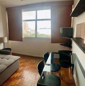 里约热内卢Fronteira Leblon/Ipanema - Vista fantástica!的客厅配有桌椅和窗户。