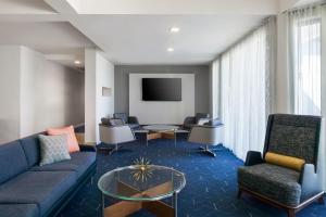凤凰城Courtyard by Marriott Phoenix Airport的客厅配有沙发、椅子和电视