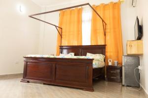 达累斯萨拉姆Morris Multi的橙色窗帘的房间的一张床位