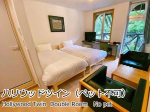 北斗市Lodge Atelier的一间卧室配有一张床、一张书桌和一台电视。