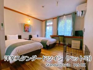 北斗市Lodge Atelier的酒店客房设有两张床和电视。