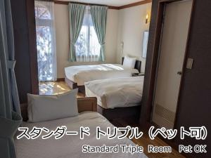 北斗市Lodge Atelier的酒店客房设有两张床和窗户。
