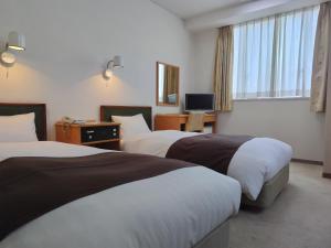 新庄New Grand Hotel的酒店客房设有两张床和电视。