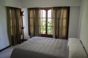 圣何塞Amplio chalet en zona centro的卧室在窗户前配有一张床