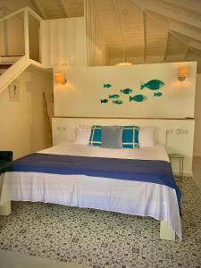 拉斯特拉纳斯PUNTA POPY Boutique HOTEL的卧室配有一张墙上有鱼的床