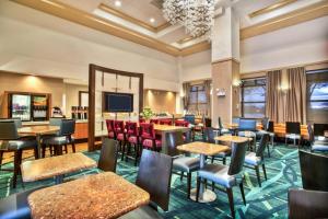 沃伦维尔SpringHill Suites by Marriott Chicago Naperville Warrenville的餐厅设有桌椅和平面电视。