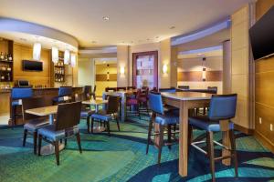 Cascade大瀑布城机场东南万豪斯普林希尔套房酒店的一间带桌椅的餐厅和一间酒吧