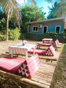 阁帕延岛family resort的一组野餐桌和长凳在房子前