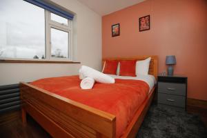 拉夫堡Contractors - Relocators - Family的一间卧室配有一张带橙色墙壁和窗户的床