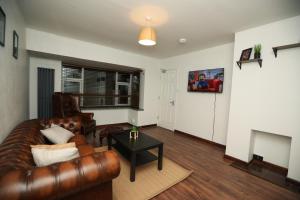拉夫堡Contractors - Relocators - Family的客厅配有真皮沙发和桌子