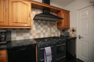 拉夫堡Contractors - Relocators - Family的厨房配有黑炉灶烤箱