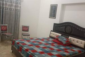 比卡内尔Salasar Sadan的一间卧室配有一张床和两把椅子
