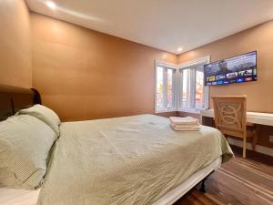 多伦多Newly Renovated Home in Toronto Near Subway的卧室配有一张床,墙上配有电视。