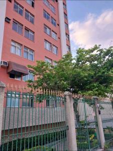 里约热内卢Magnífico apartamento的一座高大的红色建筑,前面有栅栏