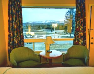 蒙特朗布朗Motel Tremblant的客房设有床、两把椅子和窗户。