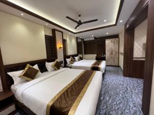 门格洛尔Hotel Mangalore Stay INN的酒店客房配有两张床和吊扇。