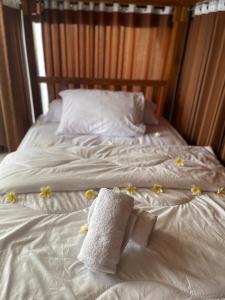 KlungkungKelingking Hostel的一张铺有白色床单和鲜花的床